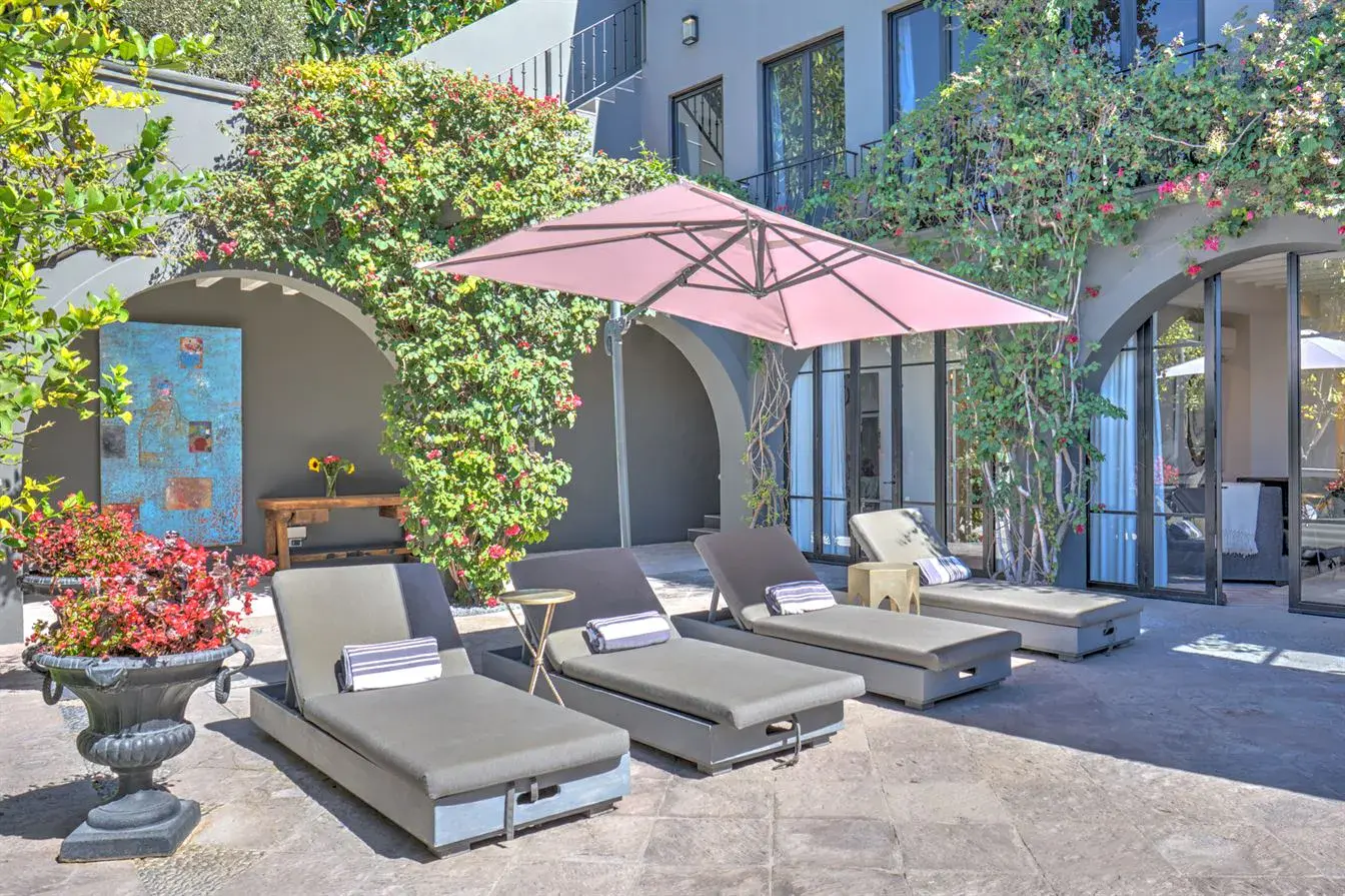Casa Arcadia, sun loungers in a courtyard under bougainvillea, San Miguel de Allende