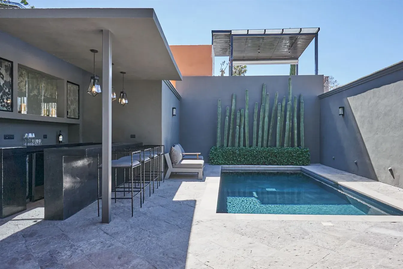Casa Arcadia, pool and covered bar with stools in a gray courtyard, San Miguel de Allende