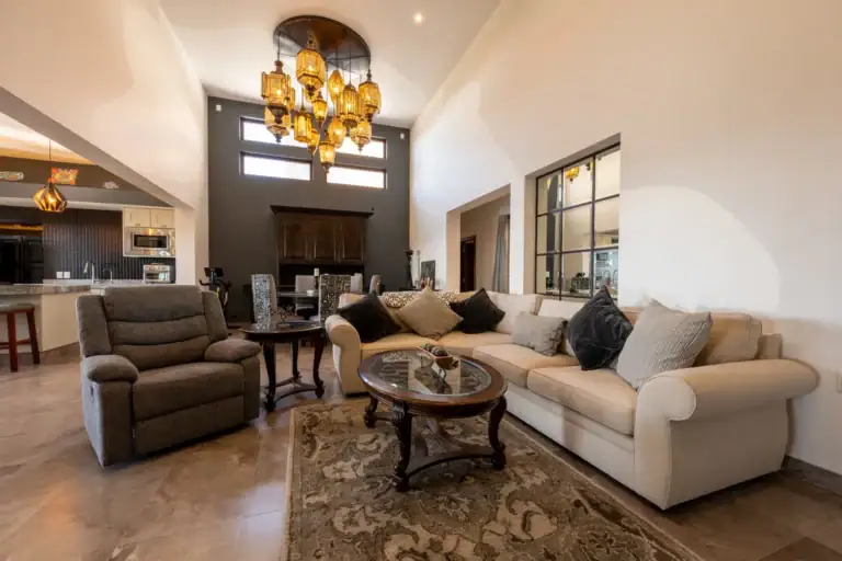 Casa Atardecer, double-height living area with a cream sectional, a recliner, a coffee table and a cluster of amber pendant lights, San Miguel de Allende
