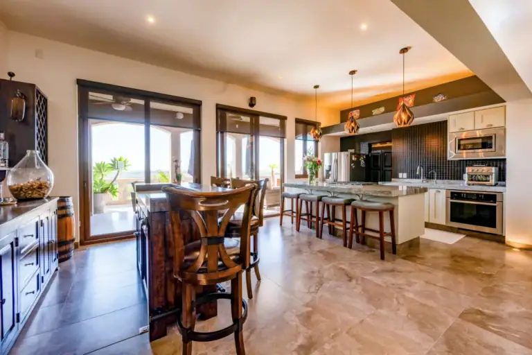 Casa Atardecer, open kitchen with a long island, bar stools, black tile backsplash and sliding glass doors to the terrace, San Miguel de Allende