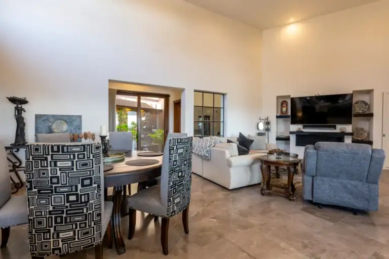 Casa Atardecer, dining table and living area with a wall television, a cream sofa and a blue recliner, San Miguel de Allende