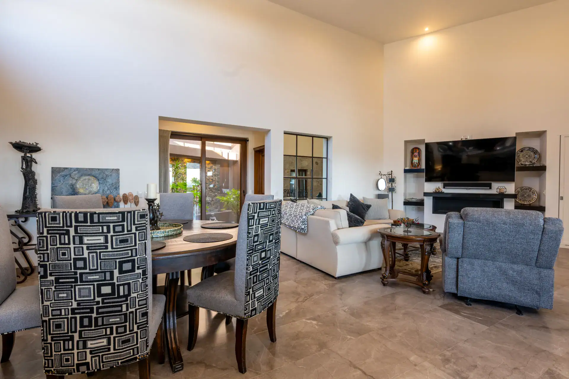 Casa Atardecer, dining table and living area with a wall television, a cream sofa and a blue recliner, San Miguel de Allende