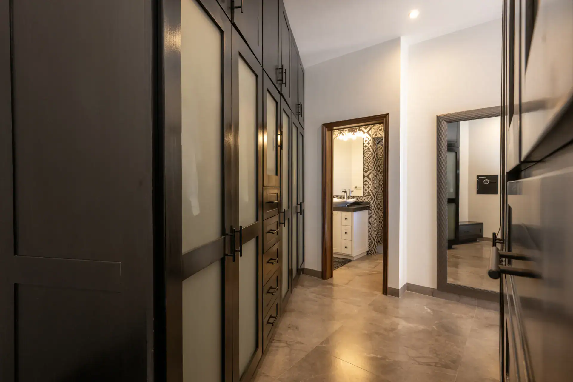 Casa Atardecer, dressing area with black built-in wardrobes with frosted glass doors and a view to a bathroom, San Miguel de Allende