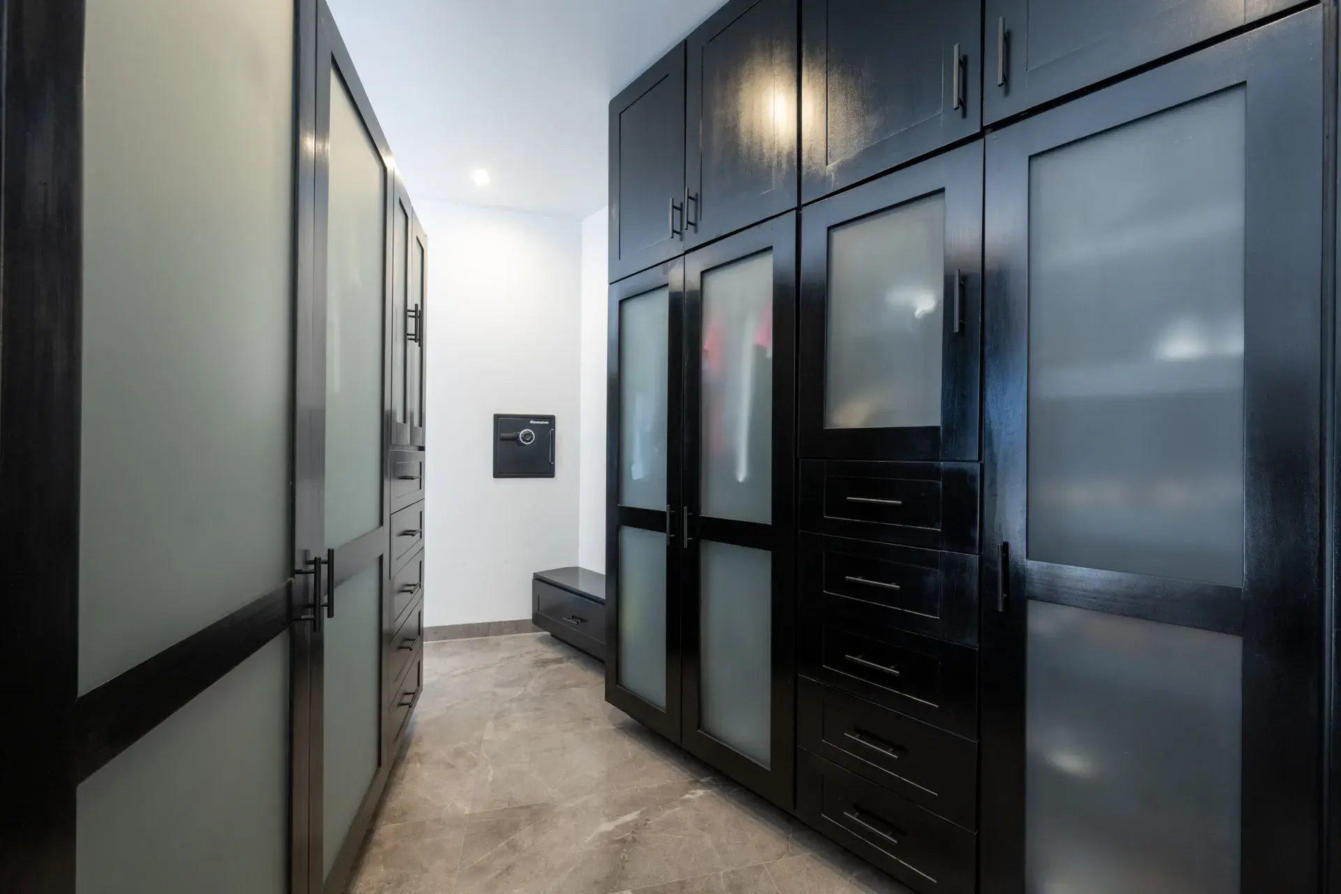 Casa Atardecer, walk-in closet with black cabinets with frosted glass and drawers and a wall safe, San Miguel de Allende