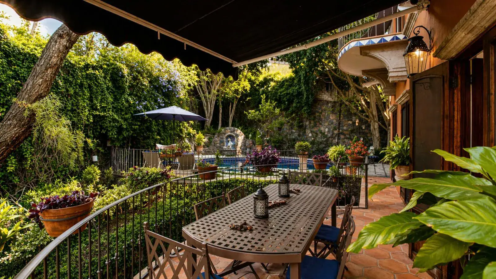 Casa Baeza, balcony dining table above a garden pool under an awning, San Miguel de Allende