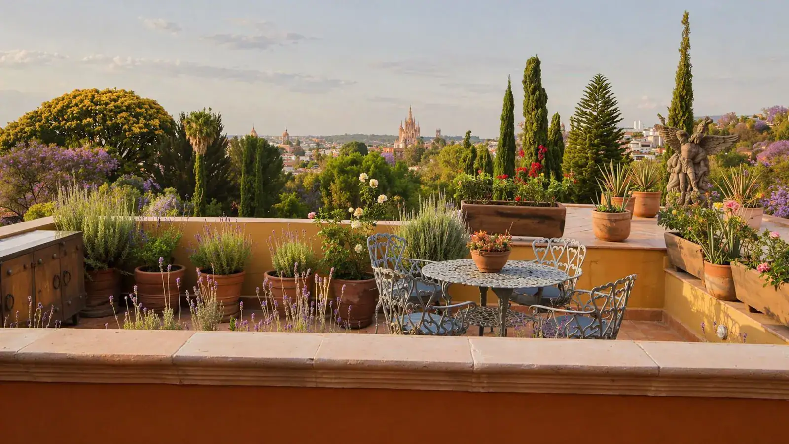 Casa Baeza, rooftop terrace with a bistro table, potted plants and a view toward the Parroquia, San Miguel de Allende