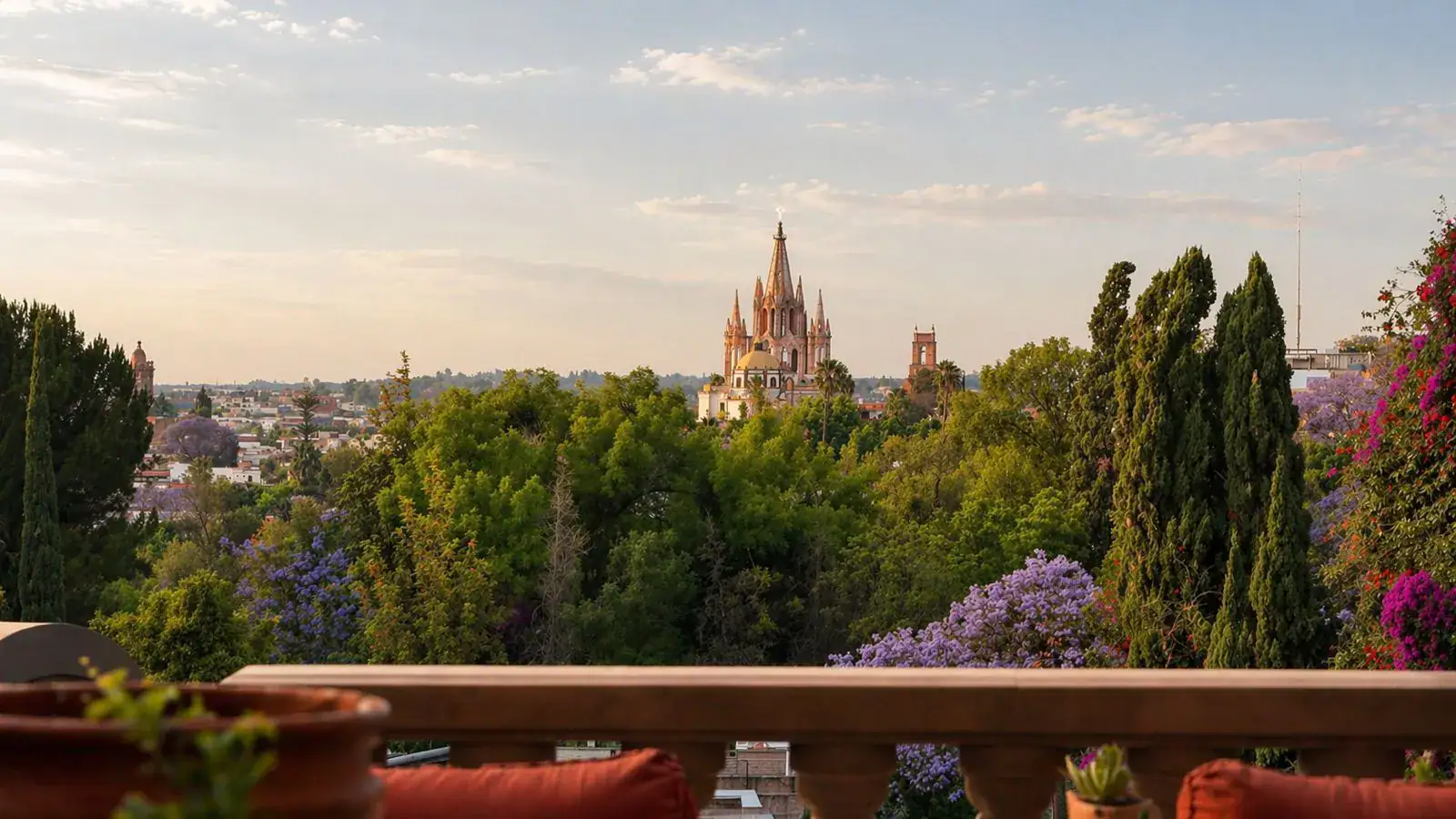 Casa Baeza, view from the terrace over treetops to the Parroquia spires at sunset, San Miguel de Allende