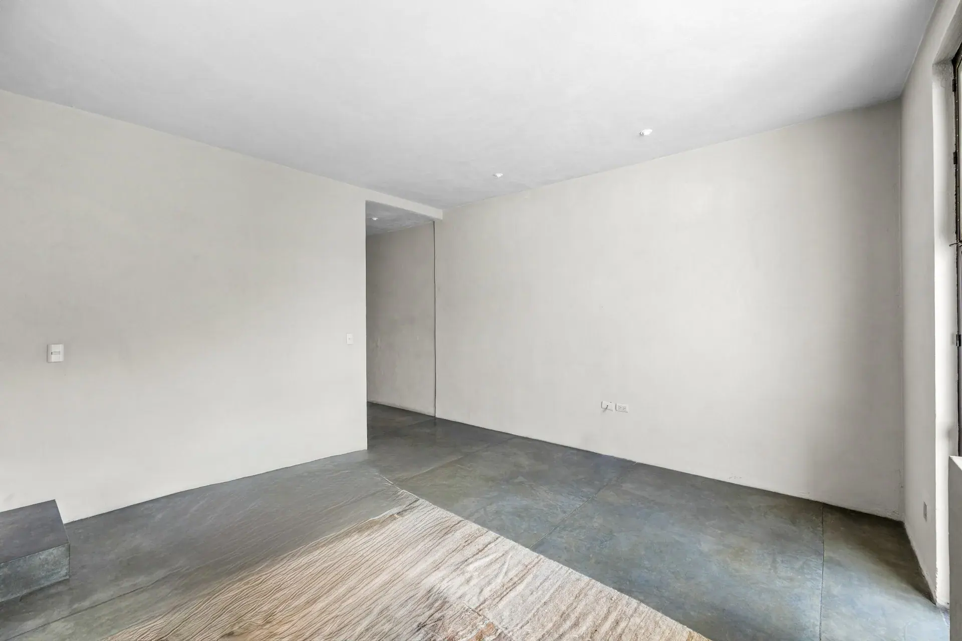 Casa Beatrice, empty room with a concrete floor and a rug beside a wall, San Miguel de Allende