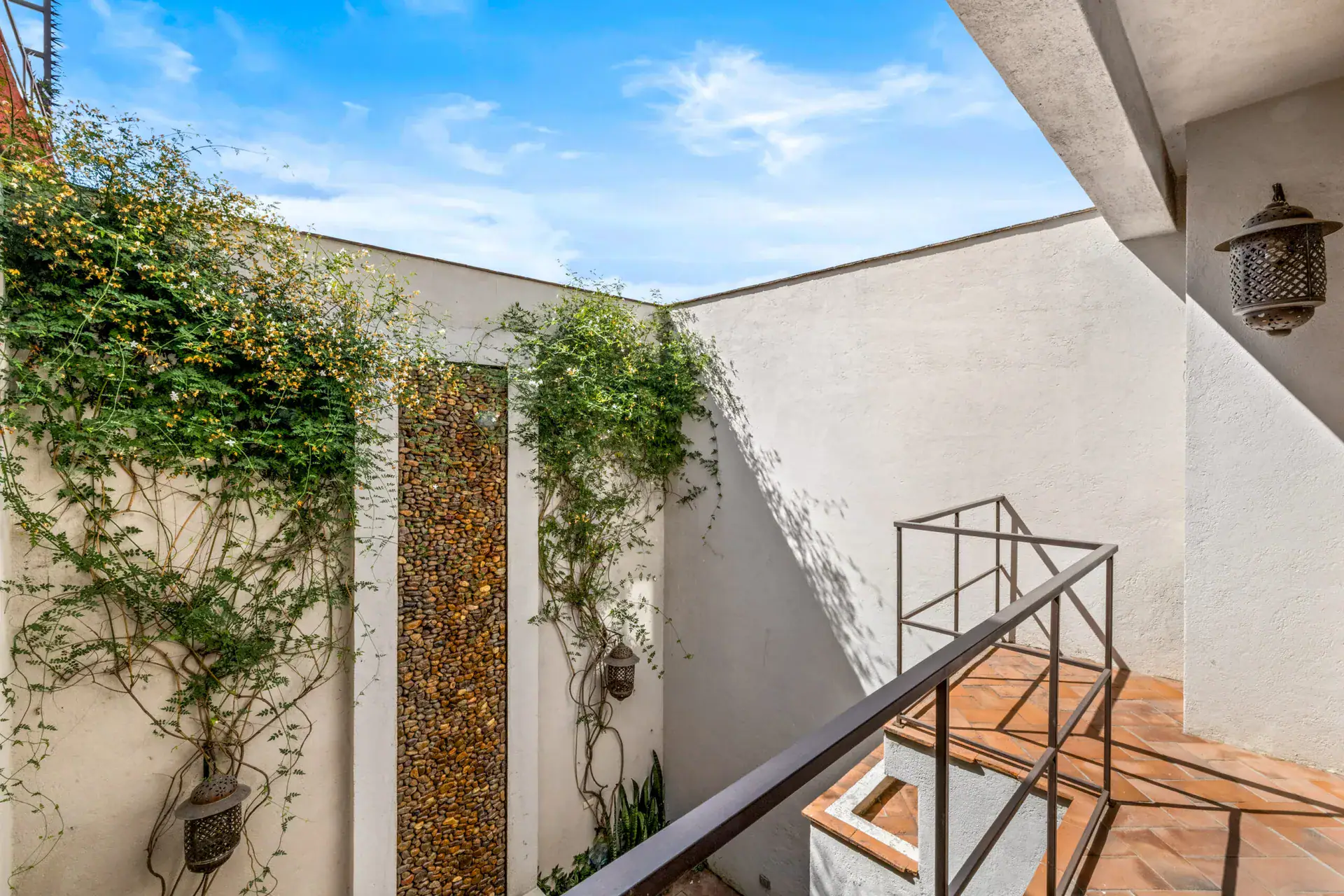 Casa Beatrice, view from the stair down into the courtyard with climbing vines and a lantern, San Miguel de Allende