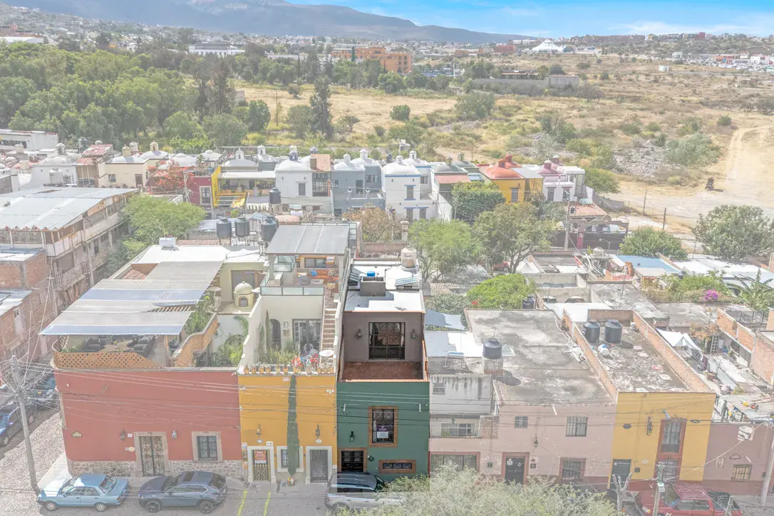 Casa Beatrice, aerial view of the colorful row of houses, the rooftops and hills in the distance, San Miguel de Allende