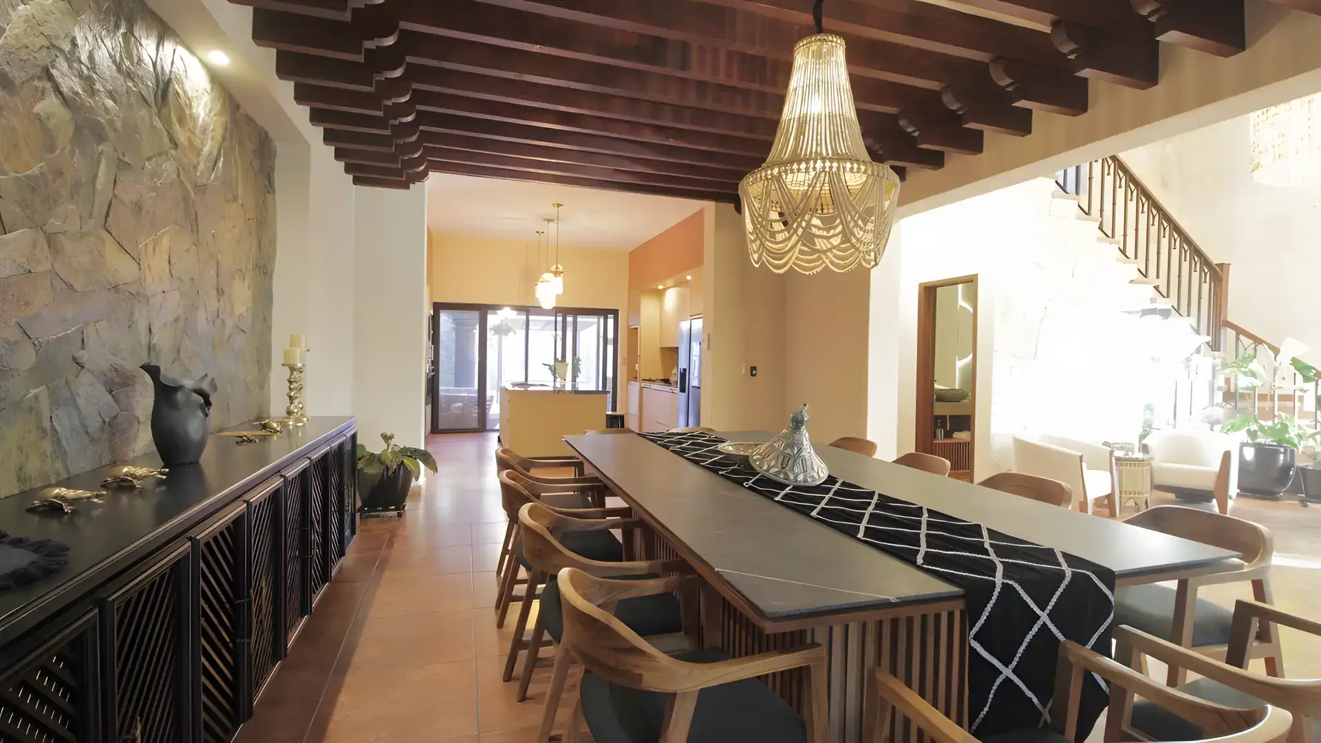 Casa Bellavista, long dining table with a black and white runner, a stone wall and a staircase beyond, San Miguel de Allende
