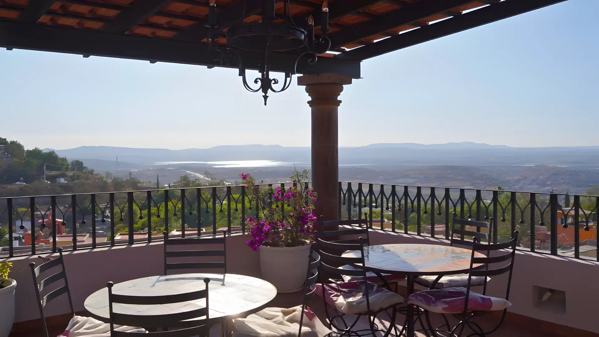 Casa Bellavista, covered terrace with a bistro table and a view over the valley and distant lake, San Miguel de Allende