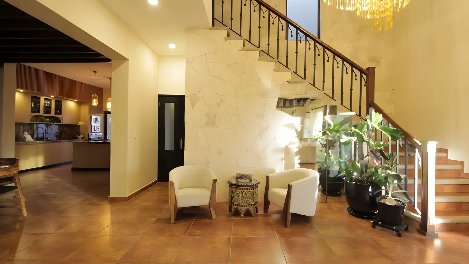 Casa Bellavista, entry hall with a stone staircase, two white chairs and a view to the kitchen, San Miguel de Allende