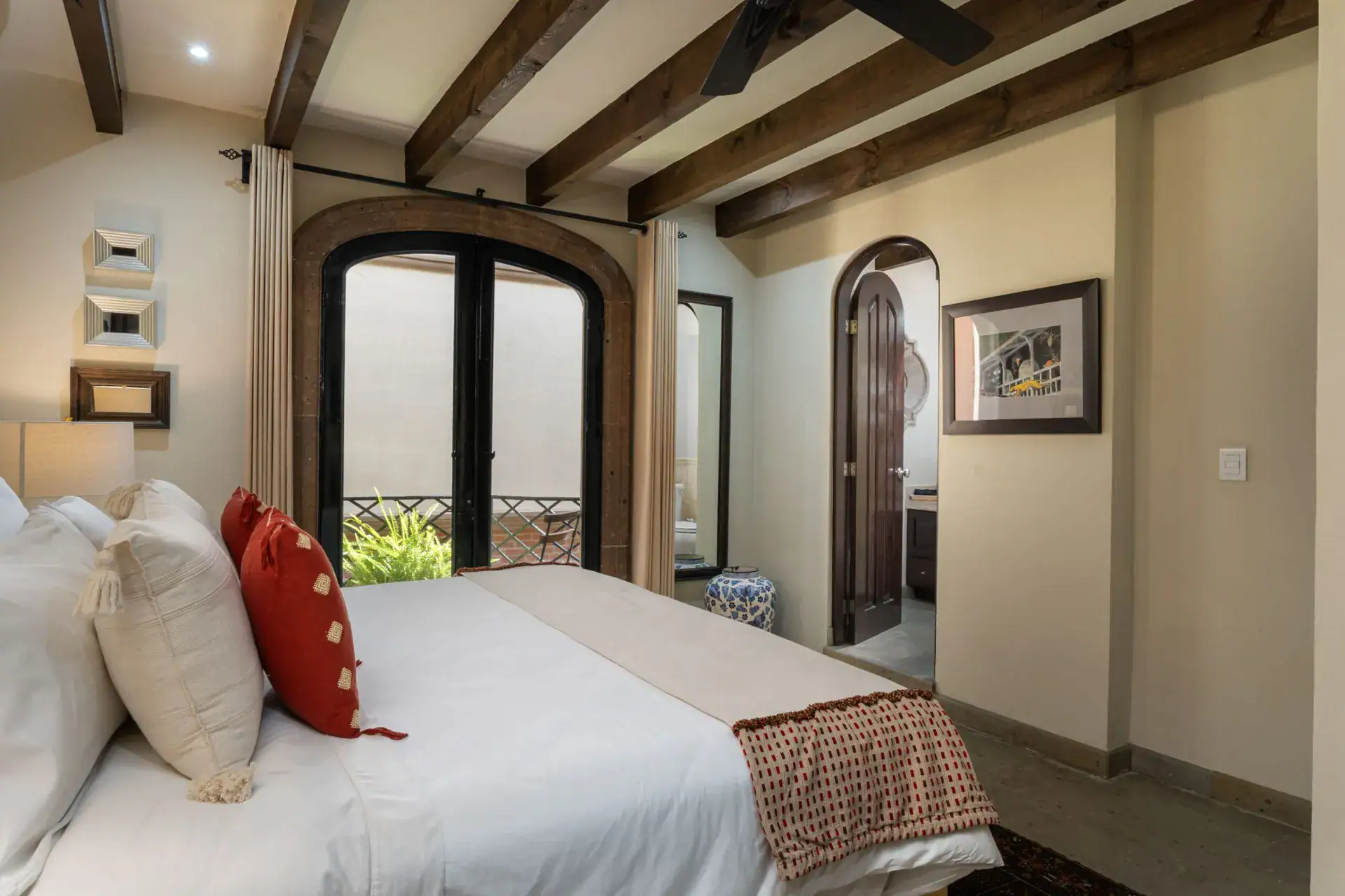 Casa Biblioteca, bedroom with French doors to a patio and an arched doorway, San Miguel de Allende