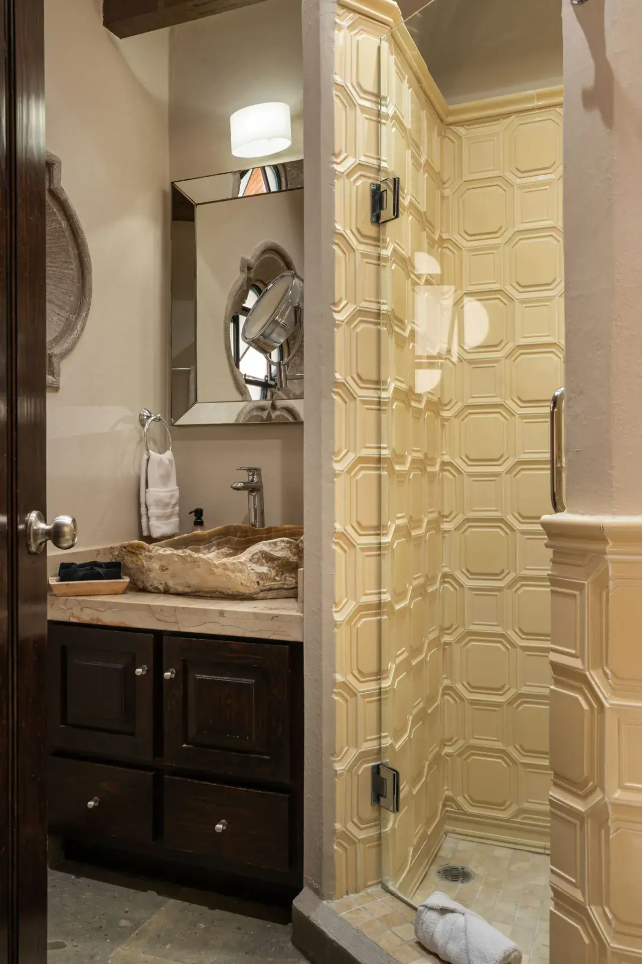 Casa Biblioteca, bathroom with a stone vessel sink and a glass shower with hexagon tile, San Miguel de Allende