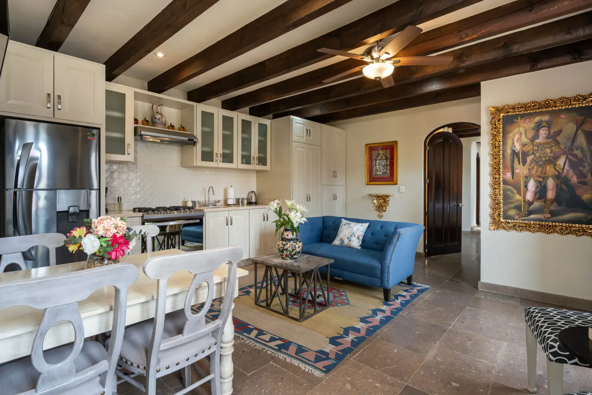 Casa Biblioteca, open kitchen and sitting area with a blue sofa and a large framed painting, San Miguel de Allende