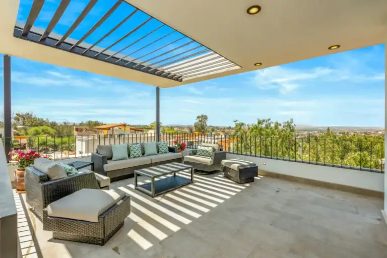 Casa Buenos Tiempos, rooftop terrace with a slatted pergola, outdoor sofas and views over the valley, San Miguel de Allende