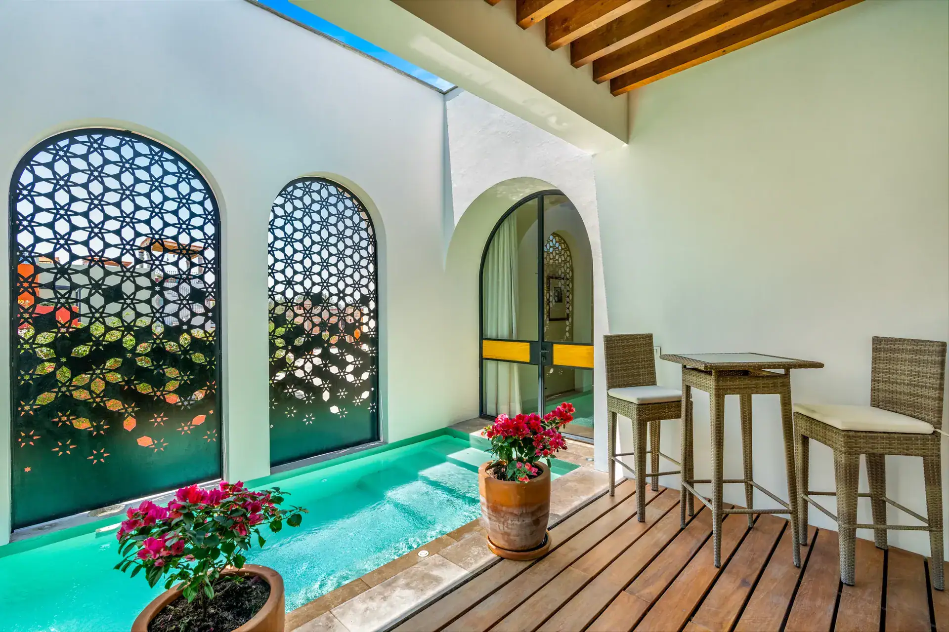 Casa Buenos Tiempos, patio with a turquoise plunge pool, a pattern-cut metal screen and high stools, San Miguel de Allende