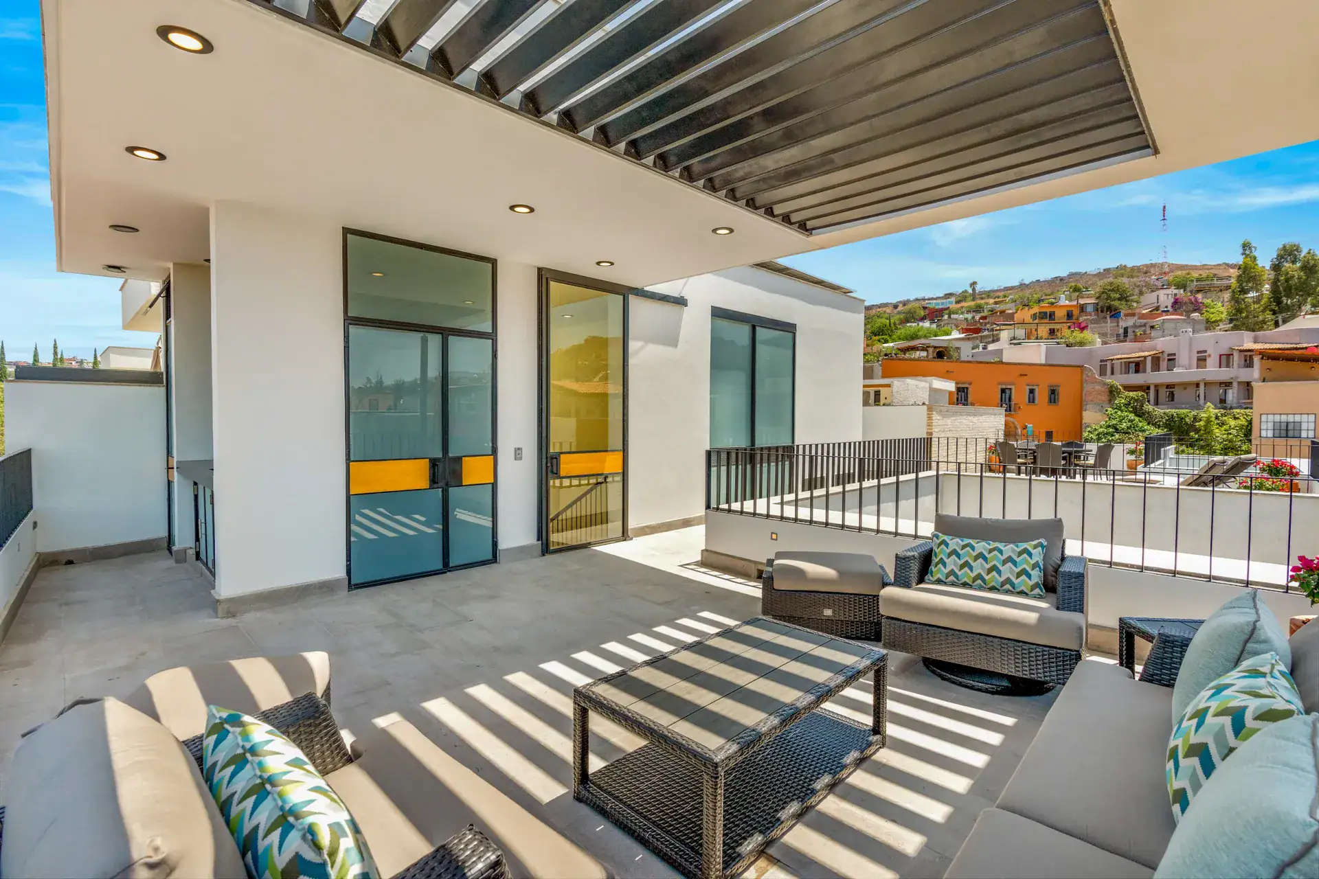 Casa Buenos Tiempos, rooftop terrace with steel-framed glass doors, outdoor sofas and a view of town, San Miguel de Allende