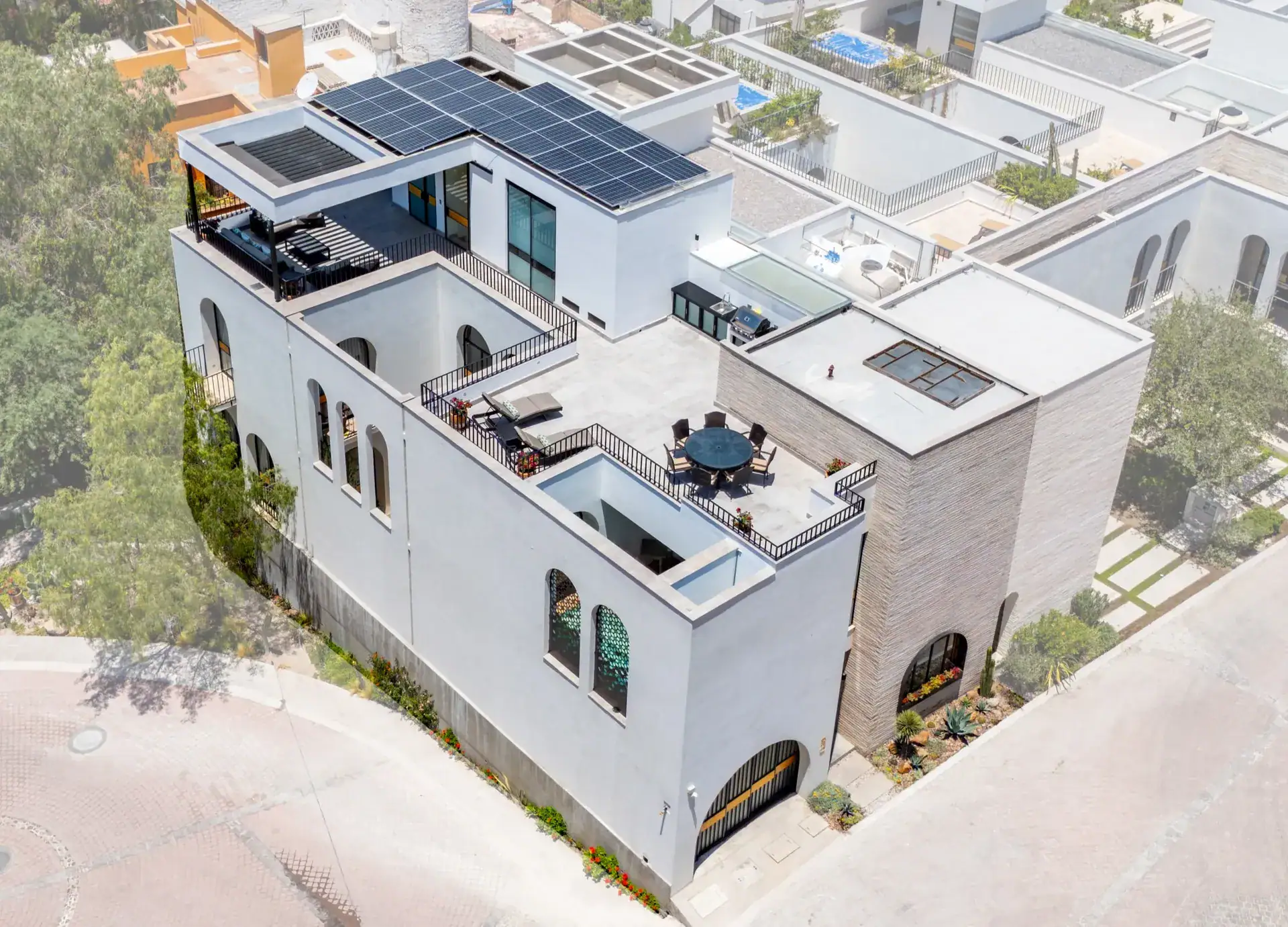 Casa Buenos Tiempos, aerial view of the house with solar panels, a rooftop terrace and surrounding homes, San Miguel de Allende