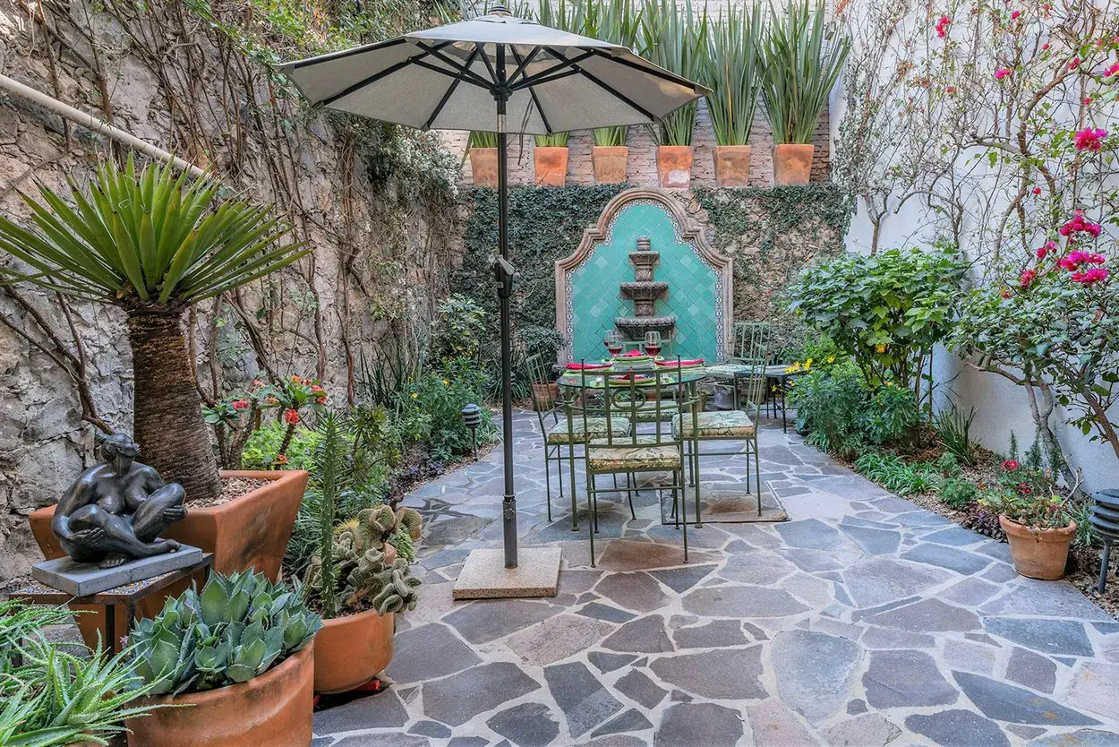 Casa Caminando, patio with a turquoise wall fountain and a dining set, San Miguel de Allende