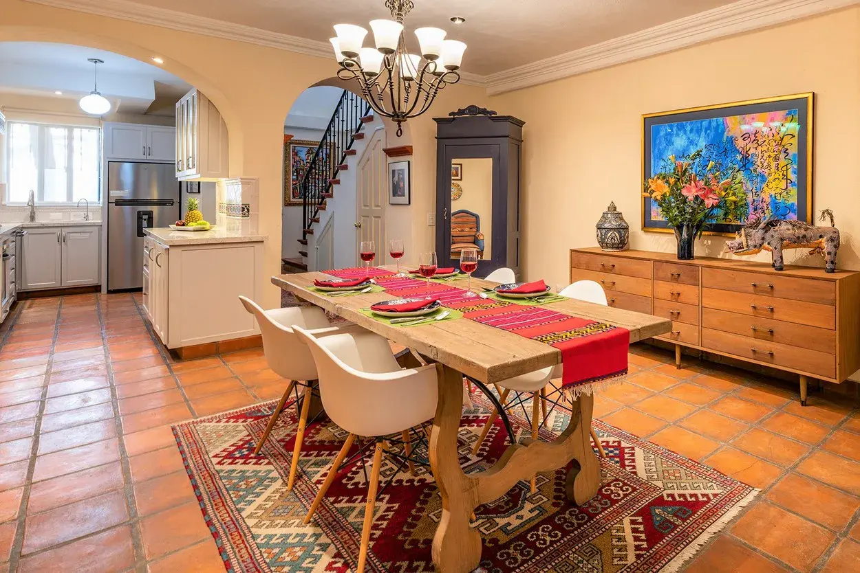 Casa Caminando, dining room with a wood table, white chairs and a chandelier, San Miguel de Allende