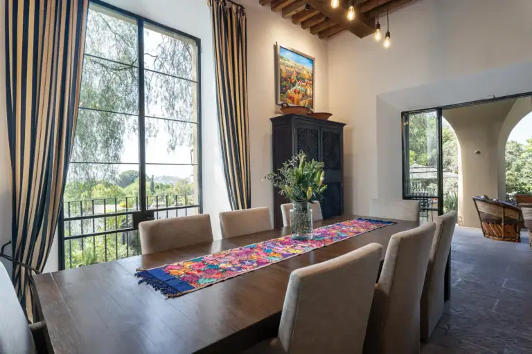 Casa Cañadita, dining table with a bright runner and a view through tall windows, San Miguel de Allende