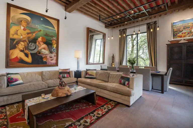 Casa Cañadita, living room with a large painting and neutral sofas, San Miguel de Allende
