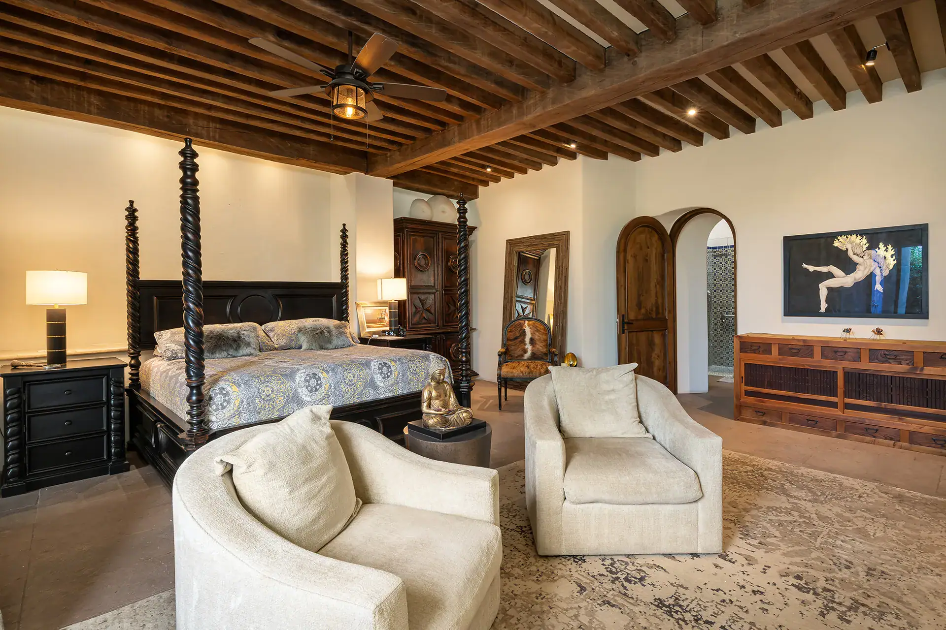 Casa Cañadita, bedroom with a four-poster bed, cream chairs and a wood beam ceiling, San Miguel de Allende