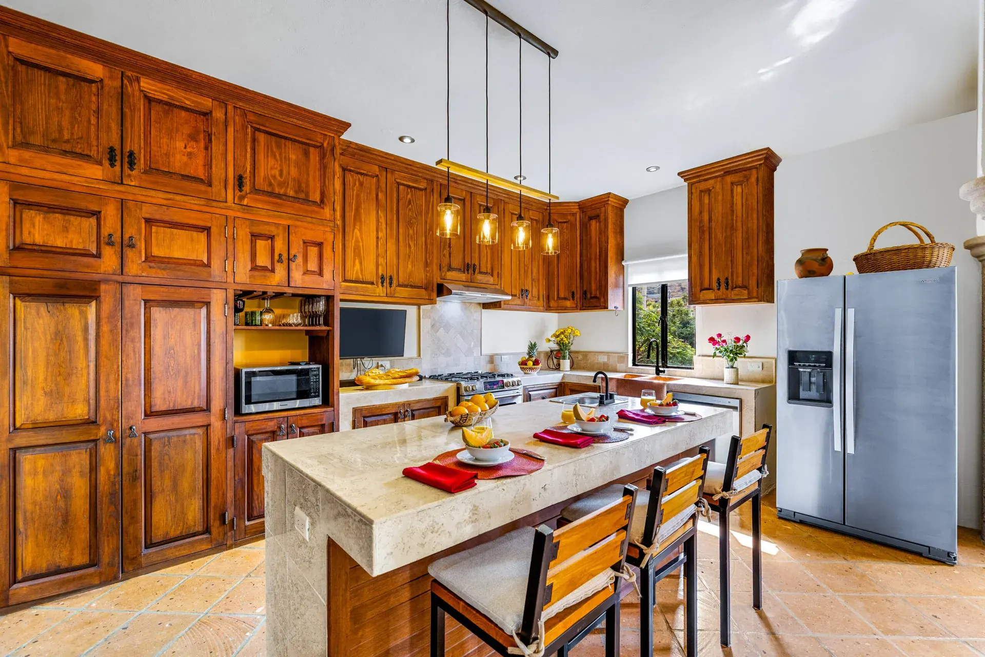 Casa Caracol Rojo, kitchen with wood cabinets, a large island and a steel refrigerator, San Miguel de Allende