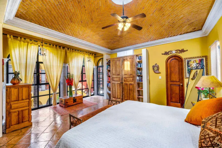 Casa Caracol Rojo, primary bedroom with a brick vaulted ceiling and gold curtains, San Miguel de Allende