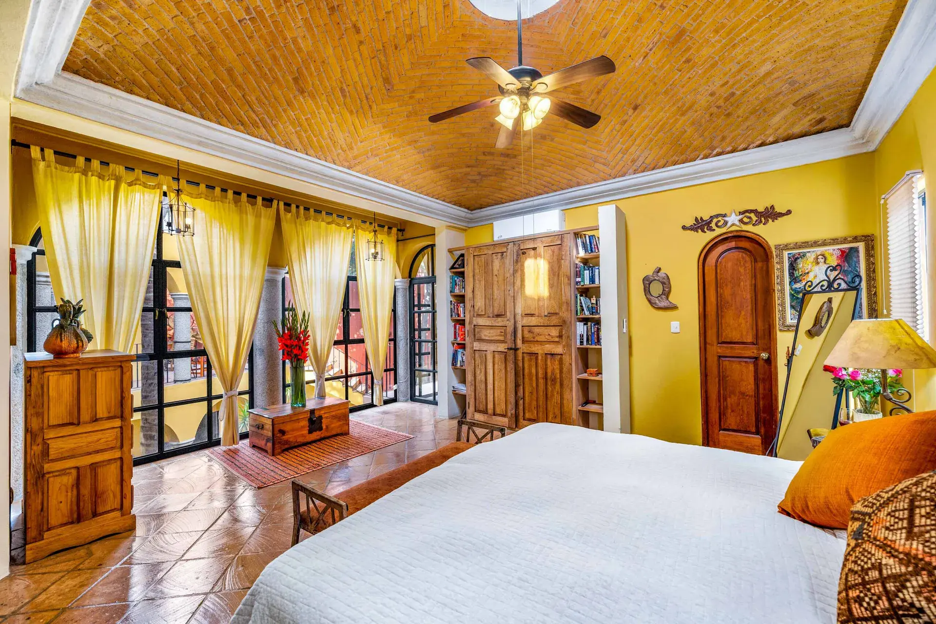 Casa Caracol Rojo, primary bedroom with a brick vaulted ceiling and gold curtains, San Miguel de Allende