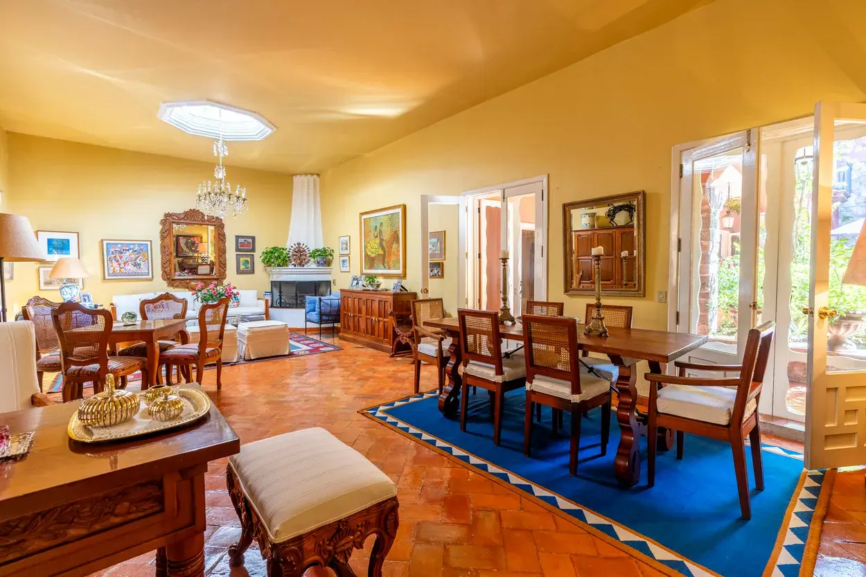 Casa Carolina, dining area with a wood table and a bright orange tile floor, San Miguel de Allende