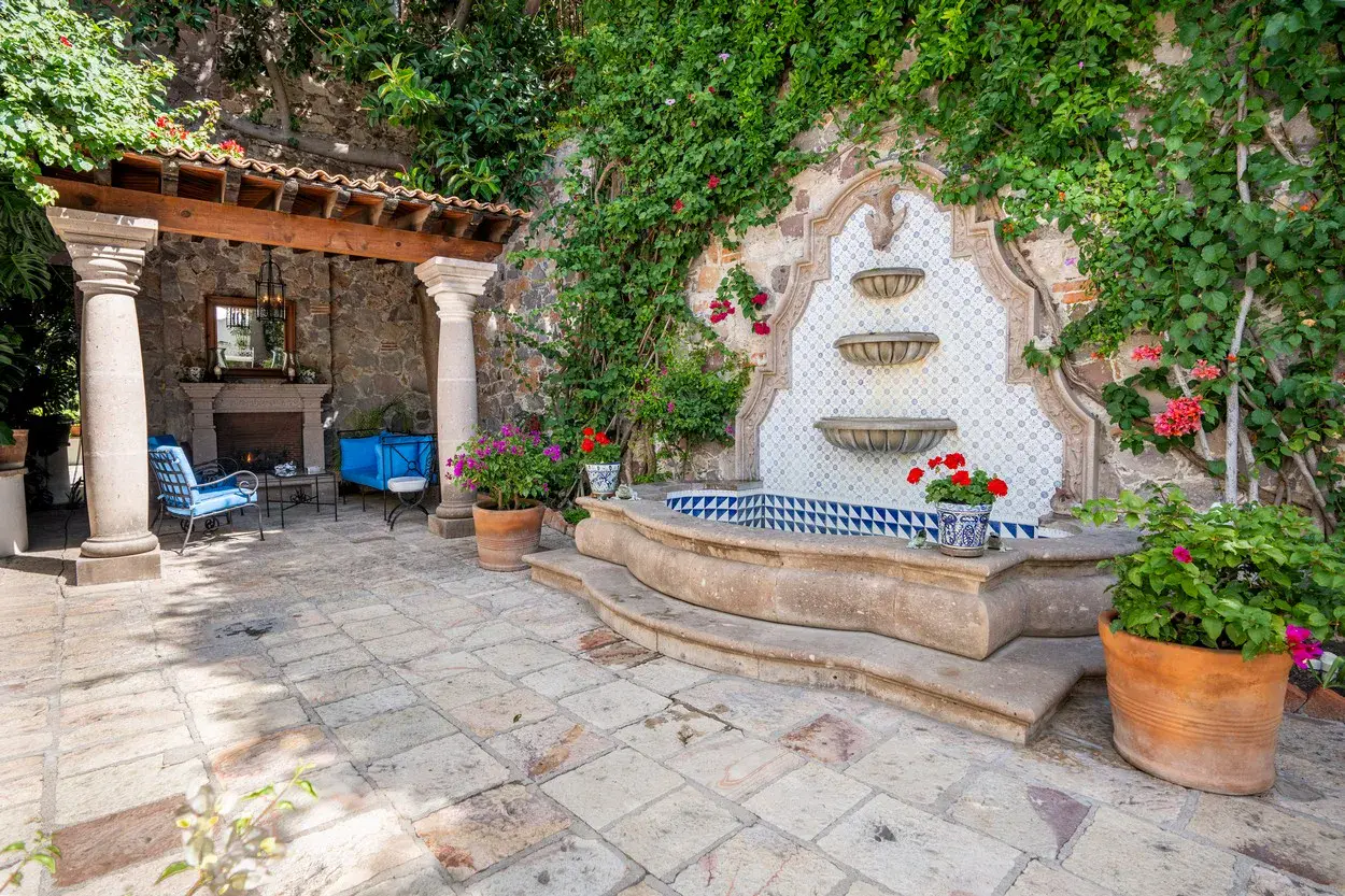 Casa Carolina, courtyard with a tiled wall fountain and a stone pergola, San Miguel de Allende