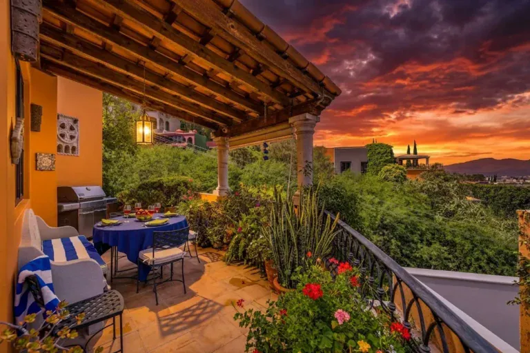 Casa Cascada, covered terrace at sunset with a grill, a dining table with blue cloth and a view over the hills, San Miguel de Allende