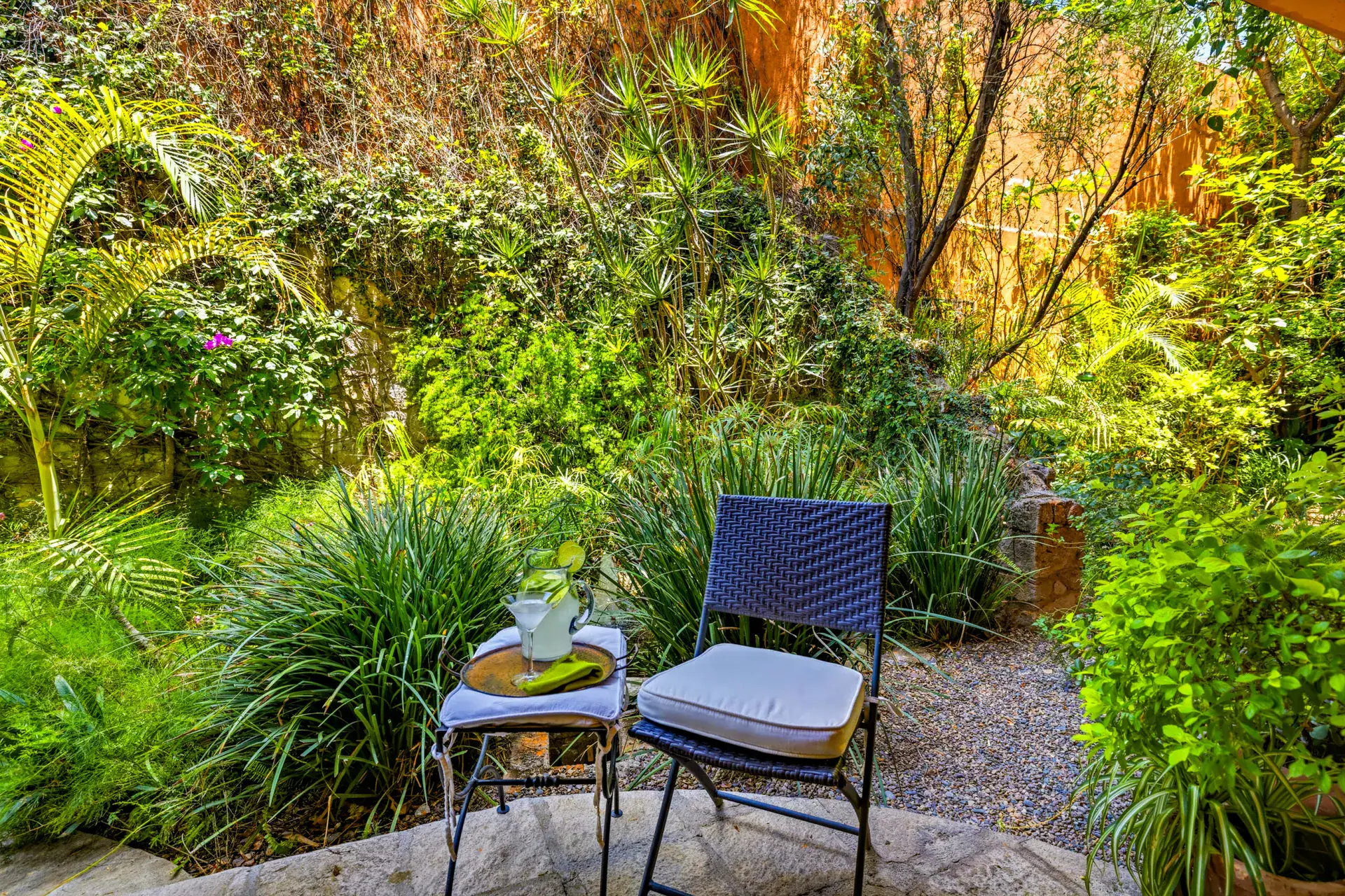 Casa Cascada, garden nook with a folding chair and side table among bamboo and ferns, San Miguel de Allende