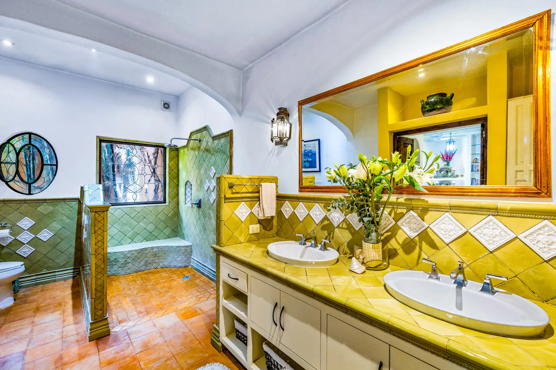 Casa Cascada, bathroom with a yellow tile double vanity, a green tile shower and a large mirror, San Miguel de Allende