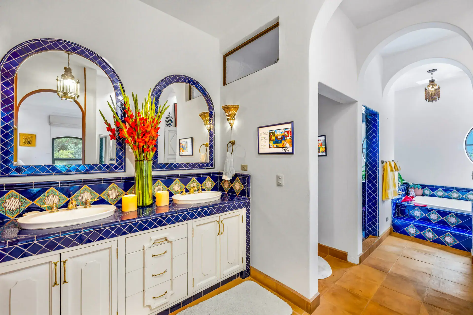 Casa Cascada, bathroom with a blue tile double vanity, arched mirrors and a tub alcove, San Miguel de Allende