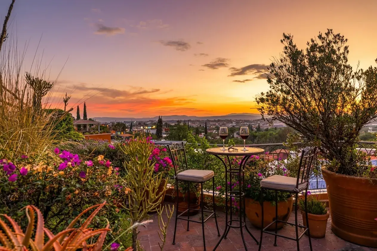 Casa Cascada, terrace at sunset with a bistro table with two glasses of wine, flowers and a view, San Miguel de Allende