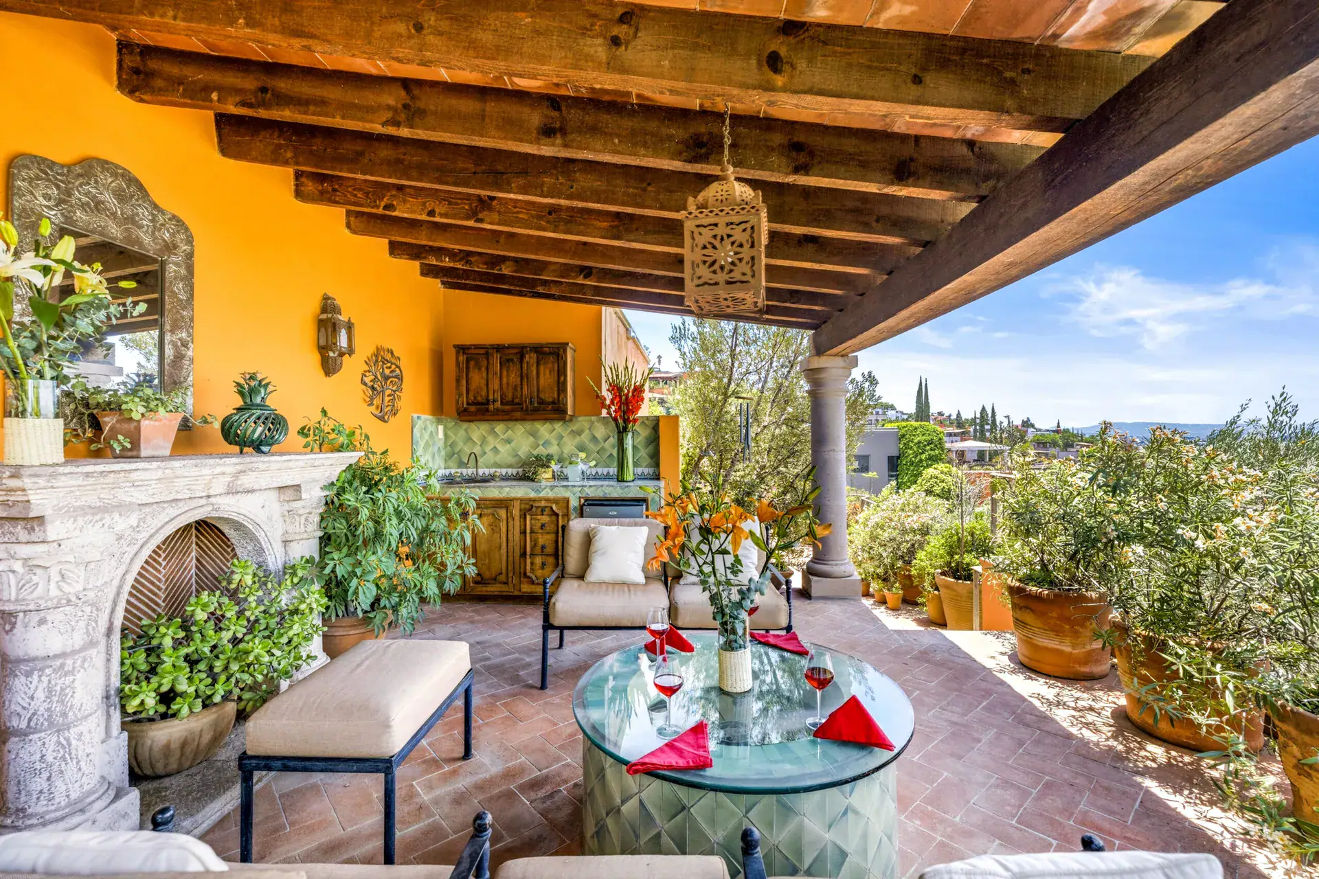 Casa Cascada, upper lounge with a carved stone fireplace, outdoor sofas and a view of the valley, San Miguel de Allende