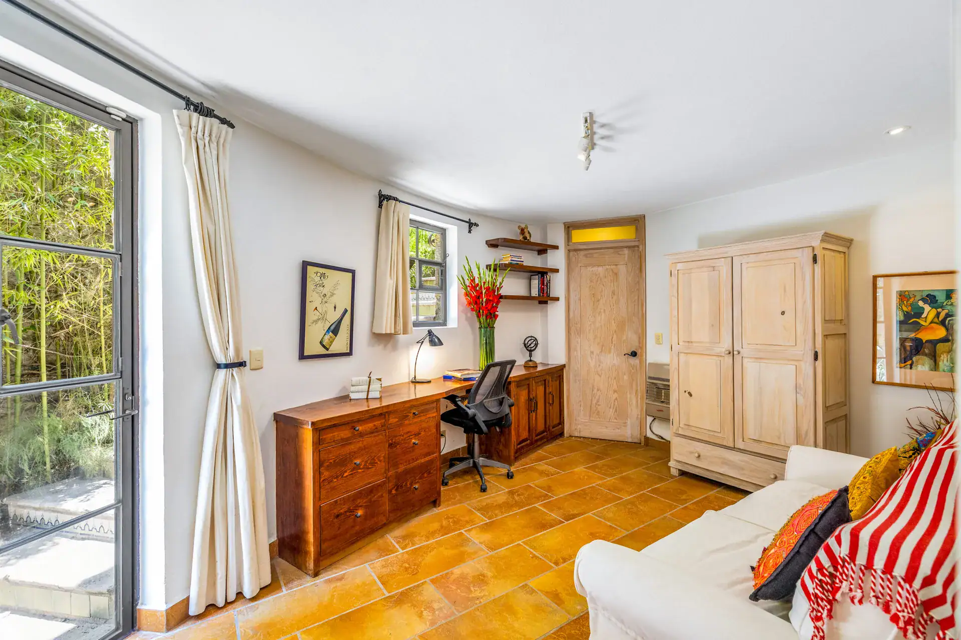 Casa Cascada, office with a wood desk, a white sofa, a wardrobe and a glass door to the garden, San Miguel de Allende