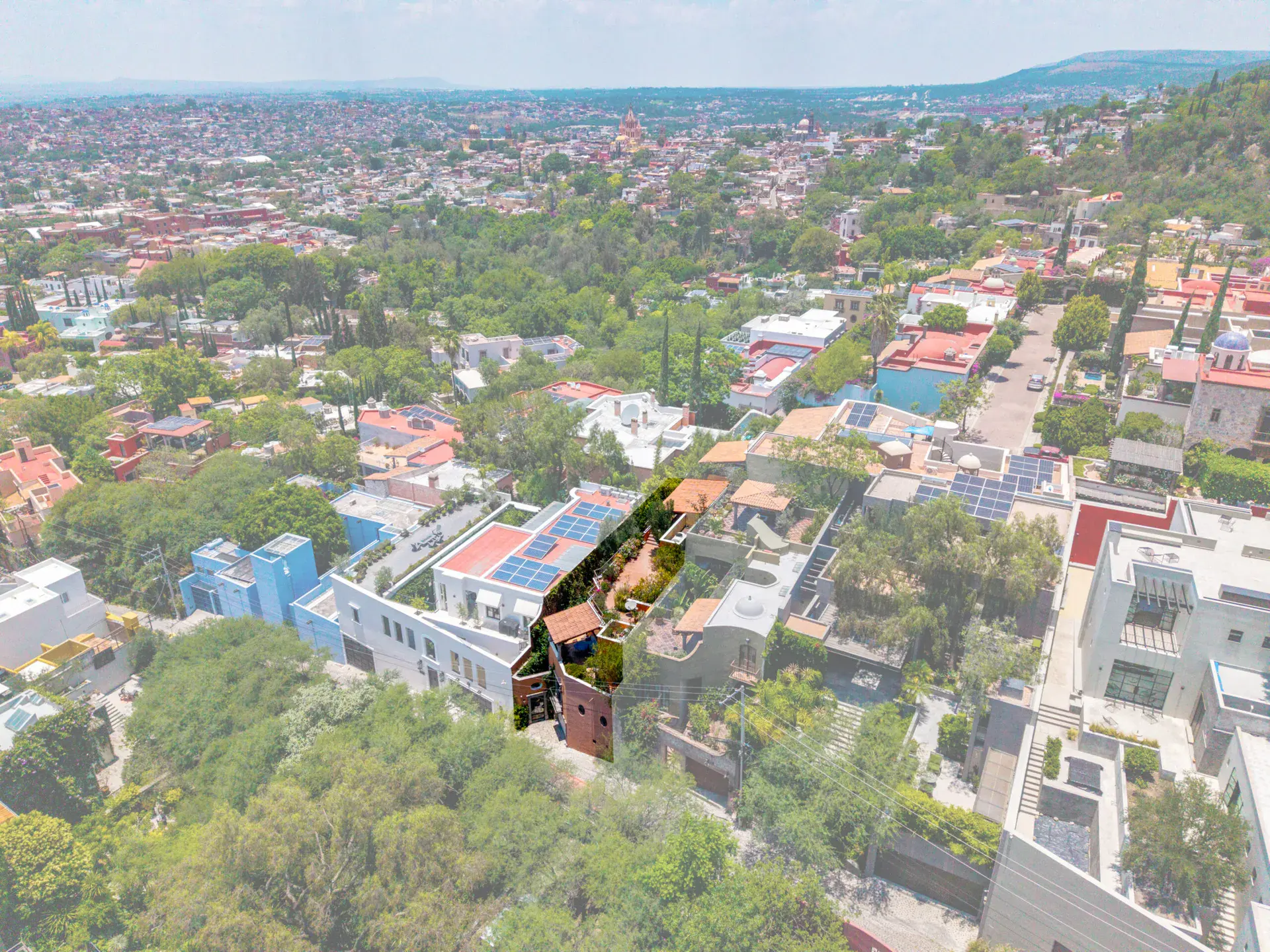 Casa Cascada, aerial view of the neighborhood with the green terraced house among rooftops, San Miguel de Allende