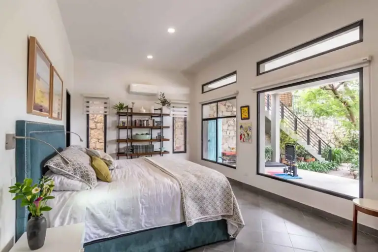 Casa Cielo Abierto, bedroom with a teal headboard, a large picture window and a view to the garden steps, San Miguel de Allende