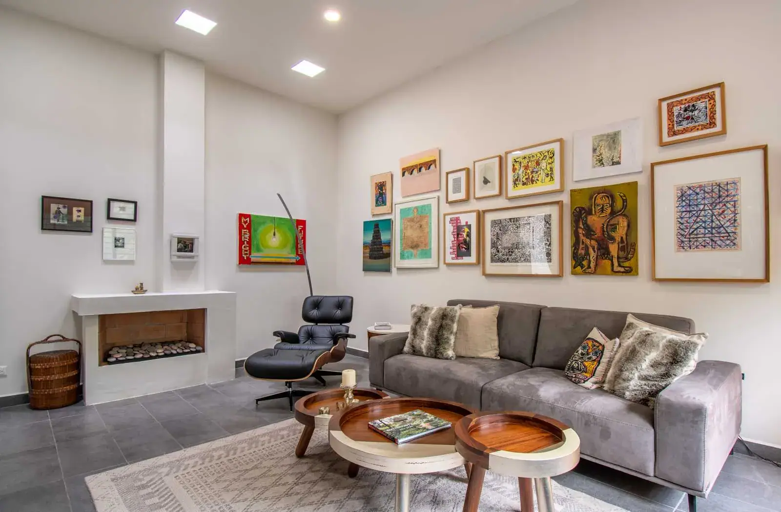 Casa Cielo Abierto, living room with a gray sofa, a gallery wall of framed art, a modern fireplace and a leather lounge chair, San Miguel de Allende
