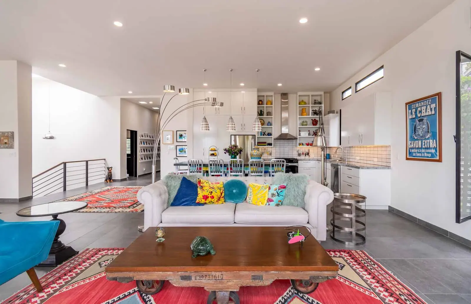 Casa Cielo Abierto, living room with a white tufted sofa, colorful cushions, a wood coffee table and the kitchen beyond, San Miguel de Allende