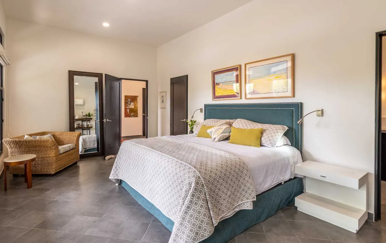 Casa Cielo Abierto, bedroom with a teal headboard, white bedding, a wicker loveseat and a mirrored door, San Miguel de Allende