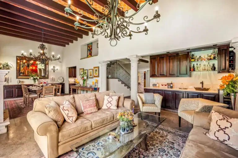 Casa Cleo Petra, living room with beige sofas, a beamed ceiling and an iron chandelier, San Miguel de Allende