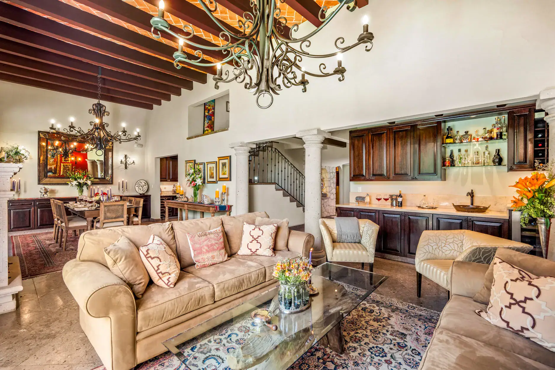 Casa Cleo Petra, living room with beige sofas, a beamed ceiling and an iron chandelier, San Miguel de Allende