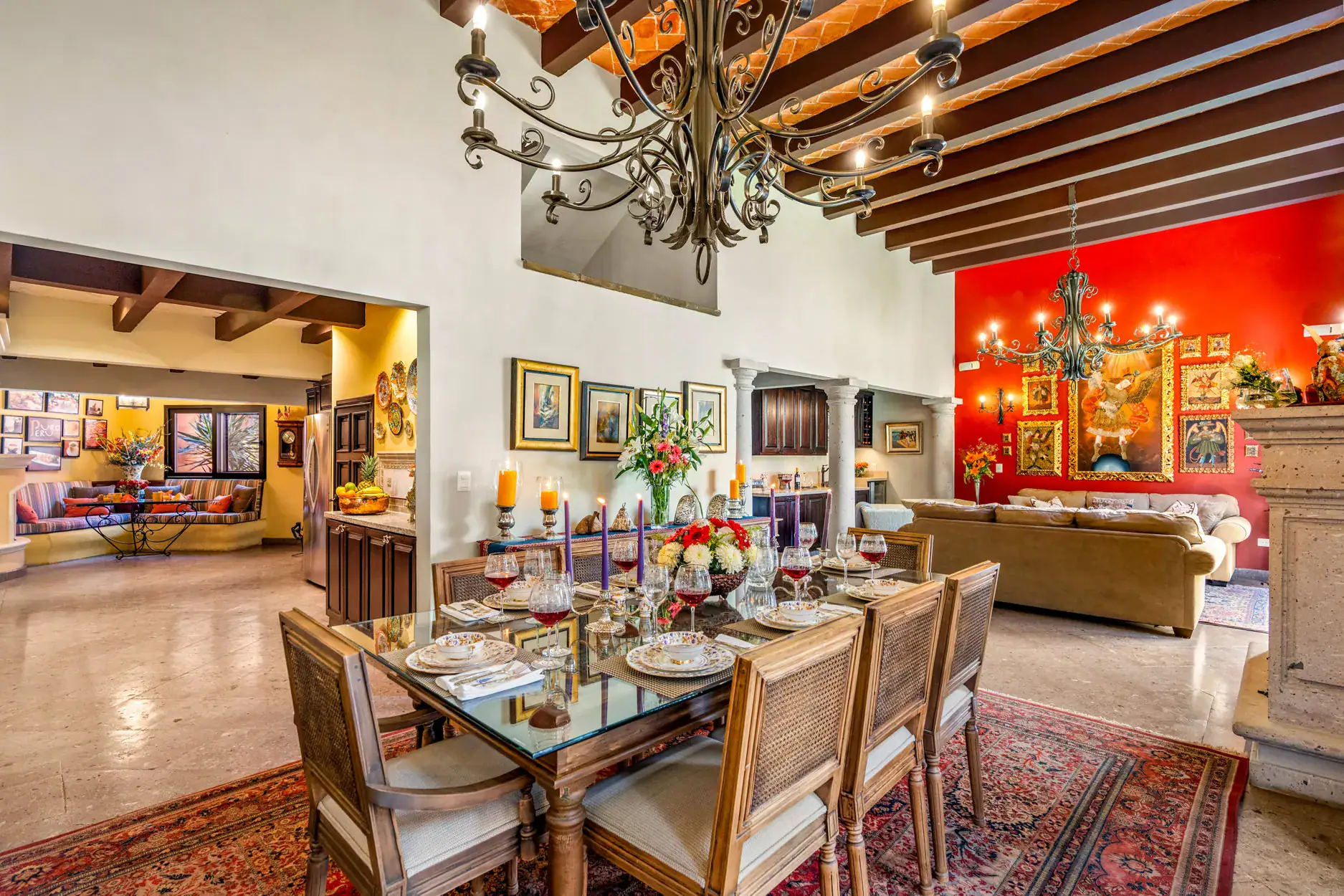 Casa Cleo Petra, dining room with a glass table and a red accent wall, San Miguel de Allende
