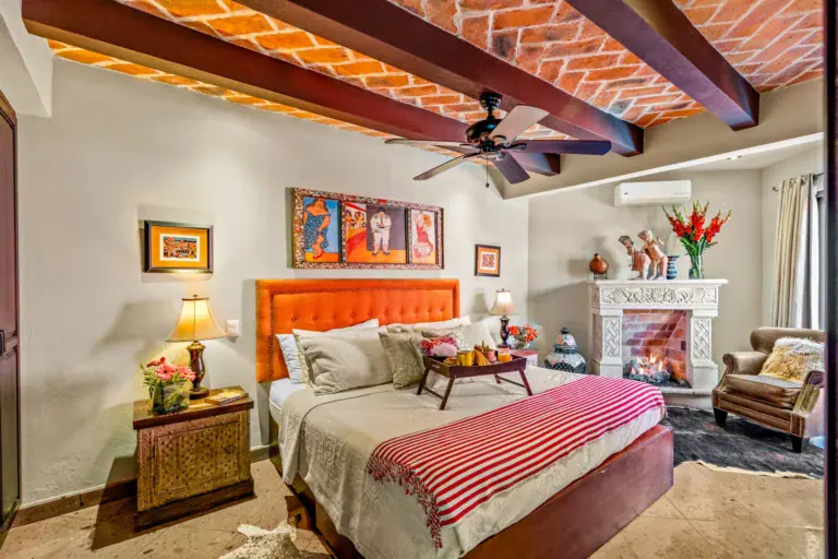 Casa Cleo Petra, primary bedroom with an orange headboard and a brick ceiling, San Miguel de Allende
